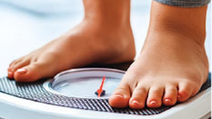 Photo of person's feet standing on a scale to measure weight and weight loss.