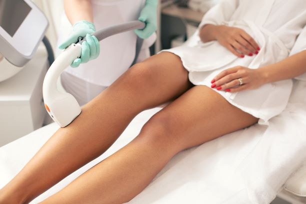 Woman receiving laser hair removal on legs