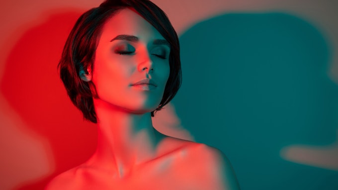 Photo of dreamy tempting pretty short hairstyle woman close eyes enjoy isolated red neon light color background