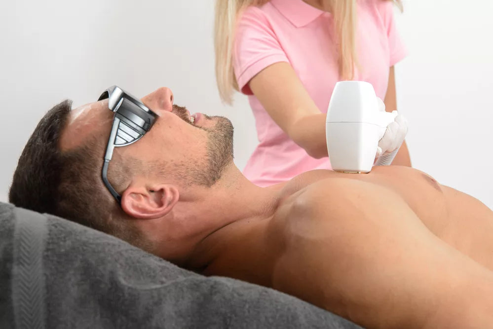 Laser hair removal on mans chest. man in a goggles.