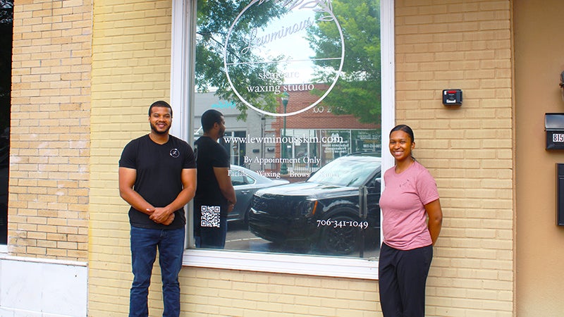 Skincare and waxing studio: Lewminous owner Britney Lewis (right) and husband Aaron Lewis (left) stand in front of the brick and mortar studio in downtown West Point. Photo contributed.