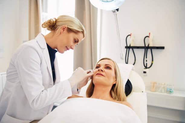 female dermatologist doing botox injections to a blonde female patient