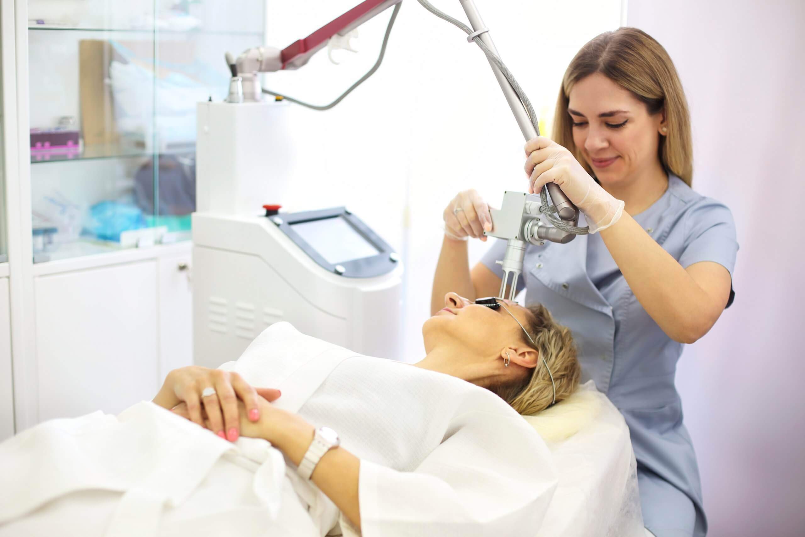 laser technician uses aesthetic lasers to treat client