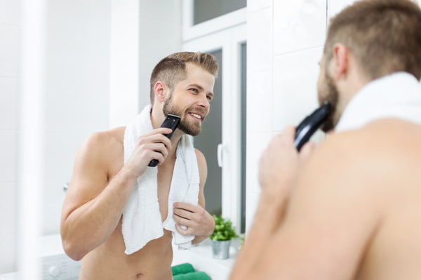 Man Shaving His Face With A Body Trimmer