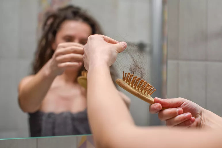 woman with pcos losing hair on hairbrush