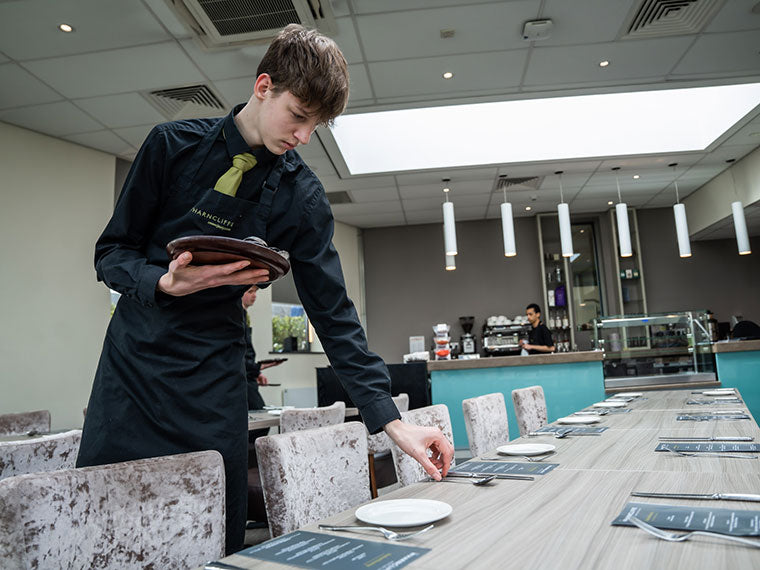 A student laying a table at The Wharncliffe