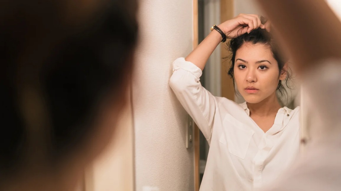 woman looking in mirror